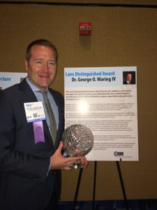 Dr. George O. Waring IV standing with 2014 Distinguished Lans Award from the international Society of Refractive Surgery